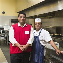 Businessman and chef standing in kitchen