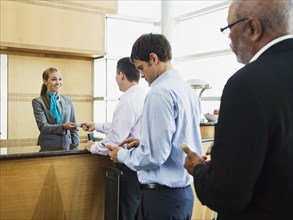 Business people in line at airport front desk