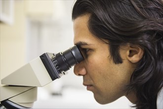 Indian scientist using microscope in laboratory