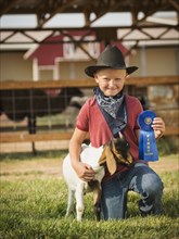 Caucasian boy with prize winning goat on farm