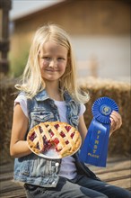 Caucasian girl with prize winning pie on farm