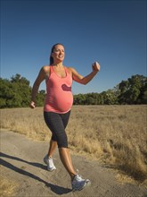 Pregnant Hispanic woman walking outdoors