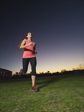 Caucasian woman jogging outdoors at sunrise