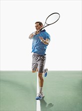 Caucasian man playing tennis on court