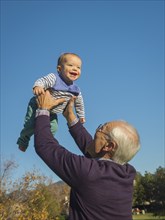 Older man playing with grandson outdoors