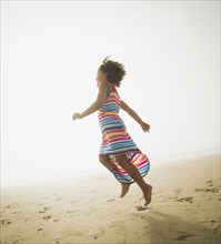 Black girl playing on beach