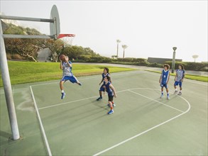Basketball teams playing on court