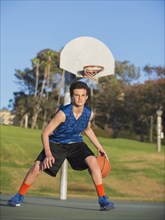 Caucasian basketball player dribbling ball on court
