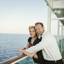 Caucasian couple hugging on boat deck