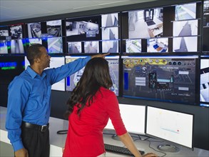 Security officers watching surveillance cameras