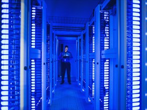 Black businessman using digital tablet in server room