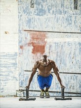 Black man doing push ups in warehouse