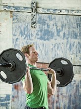 Caucasian man lifting weights in warehouse