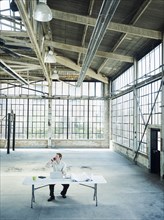 Caucasian businessman talking on cell phone in empty warehouse