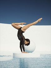 Caucasian gymnast performing hand stand on ice floe