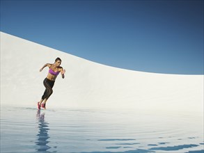 Mixed race woman running on water surface