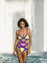 Mixed race woman wearing colorful swimsuit in swimming pool