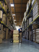 Caucasian worker using laptop in warehouse