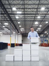 Caucasian businessman stacking boxes in warehouse