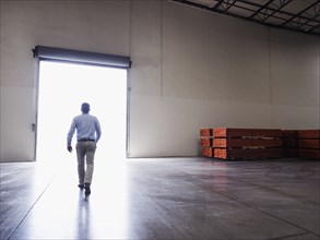 Caucasian businessman walking in warehouse