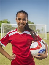 Mixed race soccer player standing on field