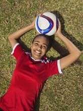 Mixed race soccer player laying on field
