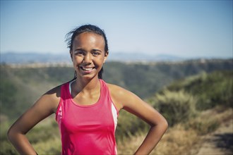 Mixed race girl smiling on hillside path