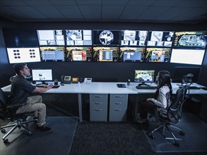 Security guards watching monitors in control room