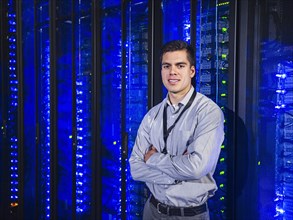 Hispanic technician smiling in server room
