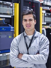 Hispanic technician smiling in server room