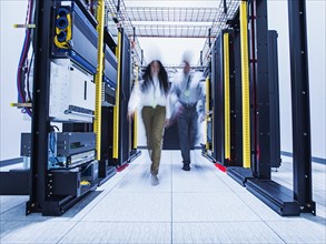 Blurred view of technicians walking in server room