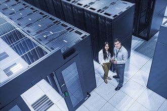 High angle view of technicians smiling in server room