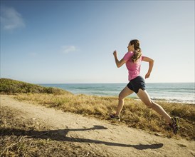Caucasian woman jogging on beach