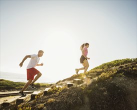 Caucasian couple jogging uphill