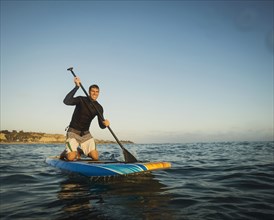 Caucasian man on paddle board in ocean
