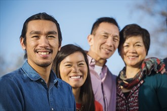 Chinese family smiling outdoors