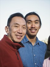 Chinese father and son smiling outdoors