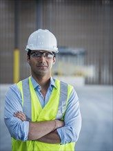 Serious Indian worker in empty warehouse