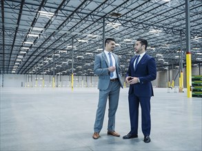 Businessmen talking in empty warehouse