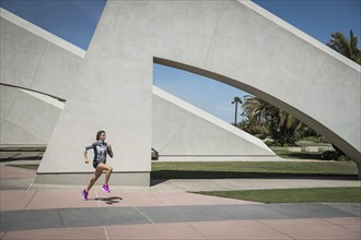 Caucasian woman running near architecture