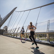 Caucasian women running on bridge