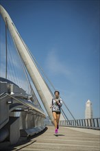 Caucasian woman running on bridge