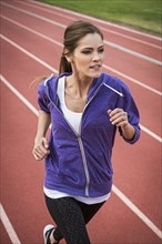 Caucasian woman running on track