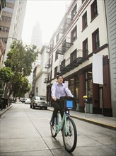 Chinese businessman commuting on bicycle in city