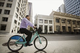 Chinese businessman commuting on bicycle in city