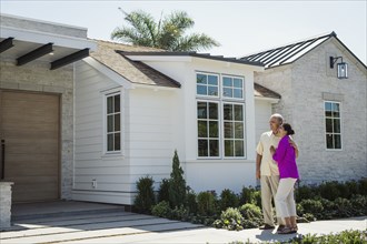 Older couple standing near driveway of house