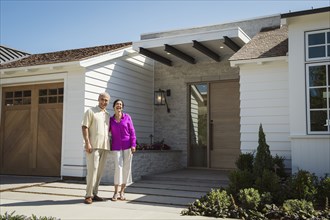 Older couple posing near driveway of house