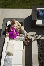 Older couple relaxing on modern backyard patio