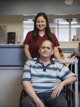 Portrait of smiling nurse and patient in wheelchair
