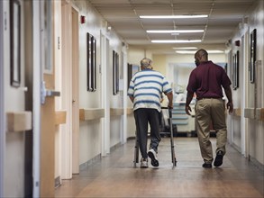 Nurse walking with patient using walker